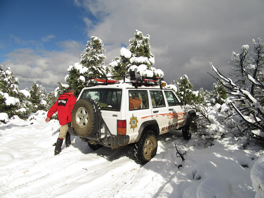 Search and Rescue member and vehicle in the snow
