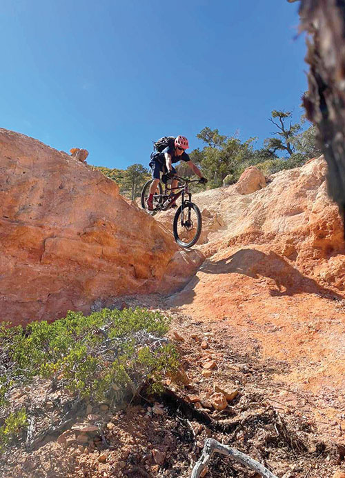A mountain biker makes his way down a steep red-rock section of Barnes Canyon