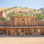 The front of an old wooden building with wagon wheels out front, Outdoor Inn