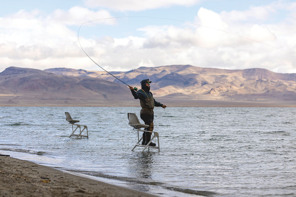 A man stands on a ladder to cast into Pyramid Lake