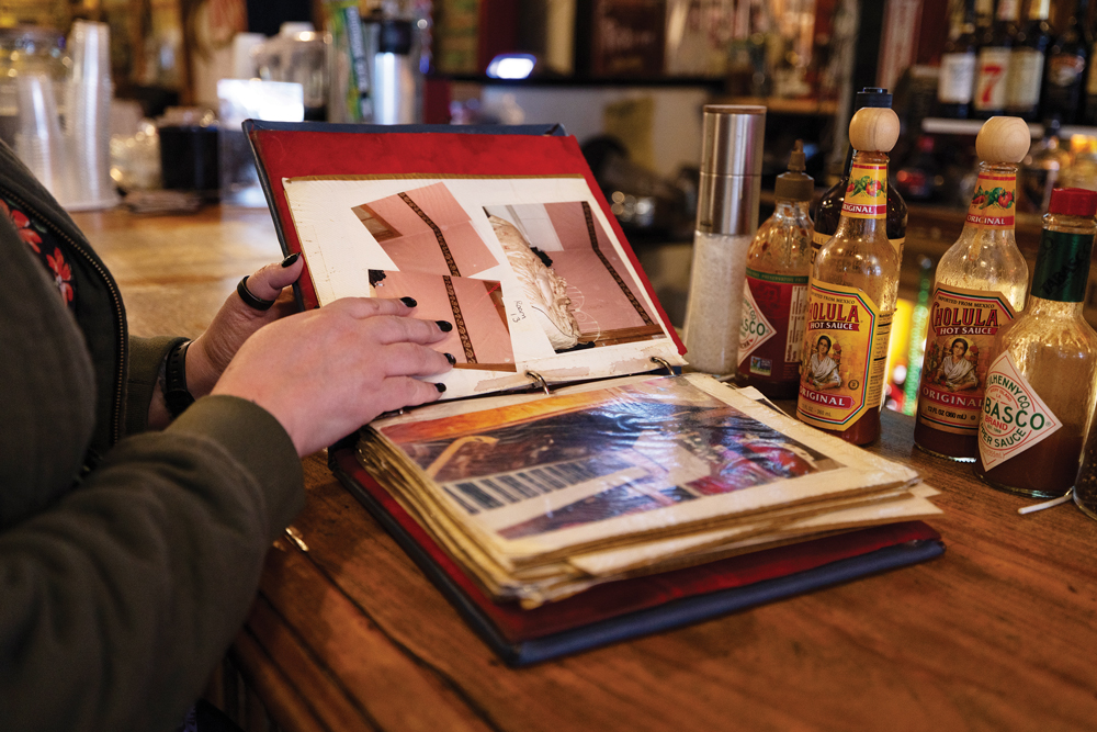 Person looking through evidence captured by guests who stayed at the Silver Queen Hotel & Saloon in Virginia City.