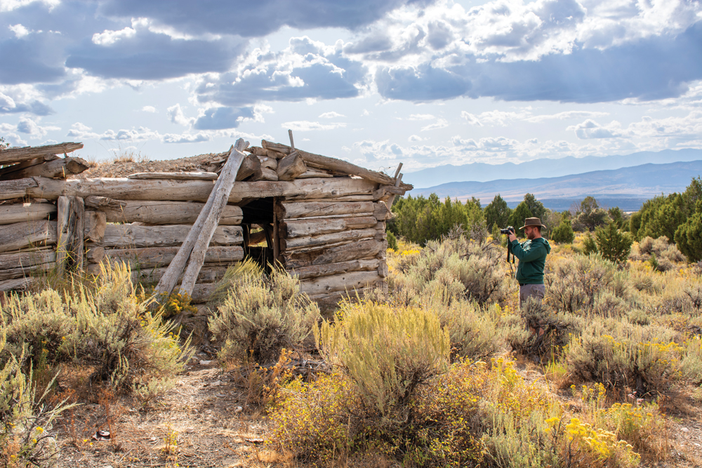 Man taking picture of remains at Ada H. Mine ghost town. 