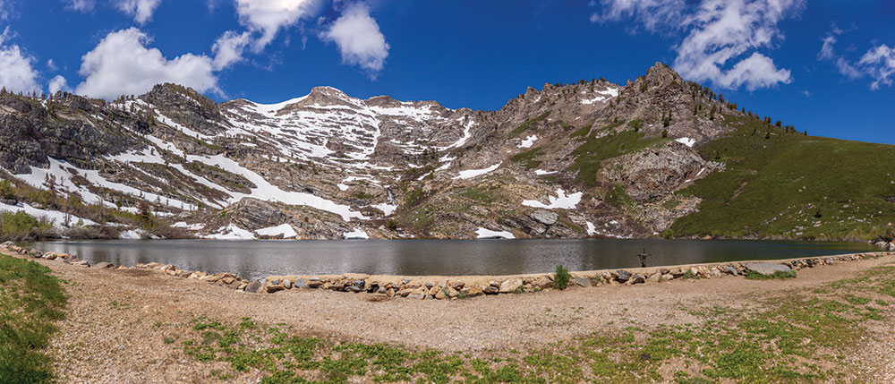 An alpine lake at the base of snow-capped mountains