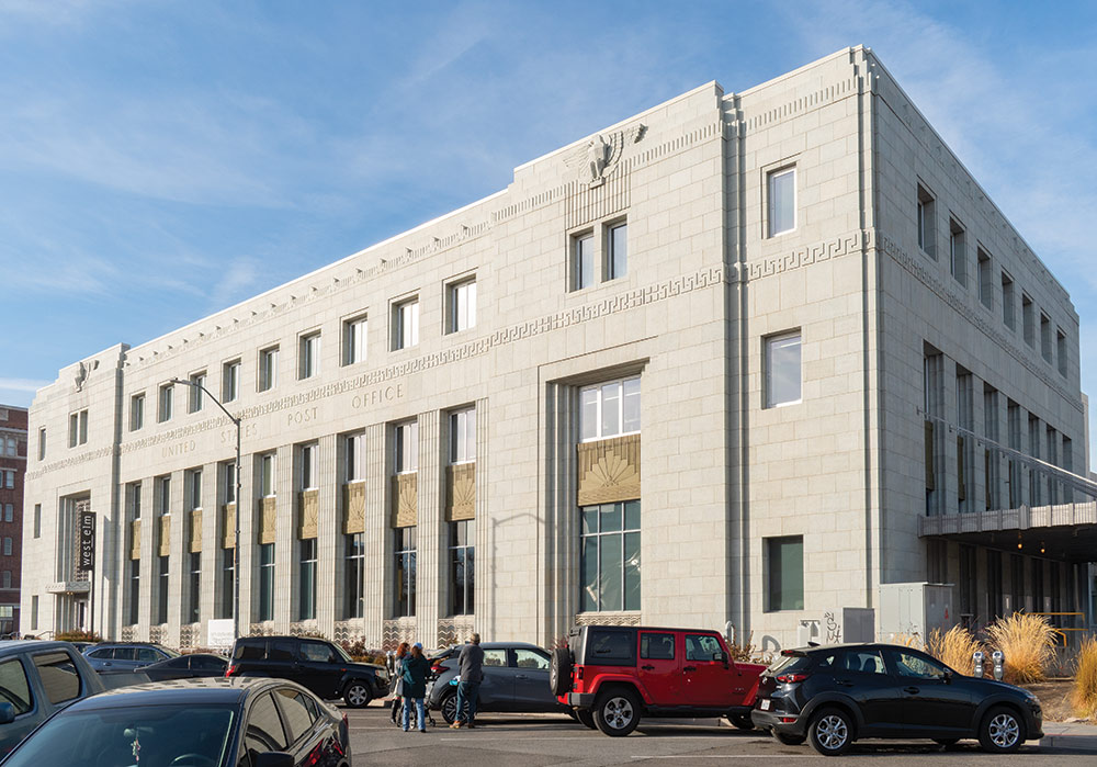 Downtown Post Office in Reno, with cars and people in front of it.