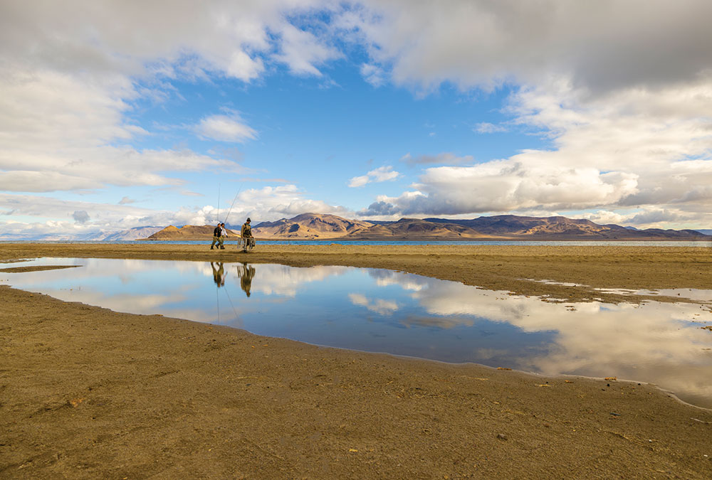 Two women and a fishing guide walk along the shore of Pyramid Lake