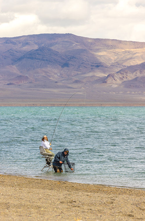 A woman catches a fish from Pyramid Lake