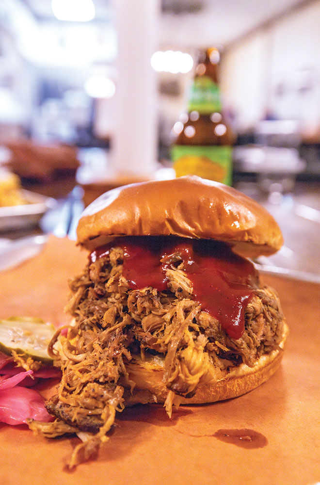 Barbecue on a bun with a beer in the background