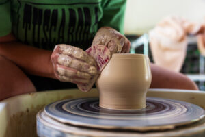 Girl throwing on a potters wheel. 