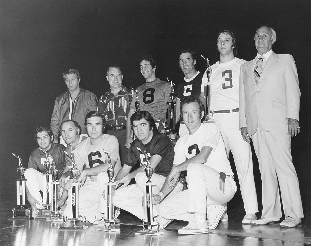 Jai alai players in black and white, posing with trophies. Historic photo.