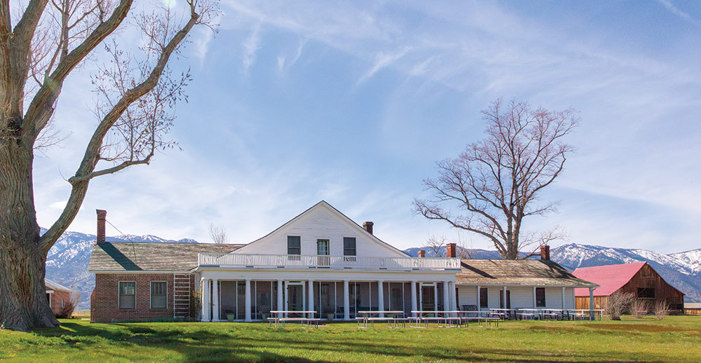 The front of Dangberg Home Ranch Historic Park, with snow-capped mountains behind.