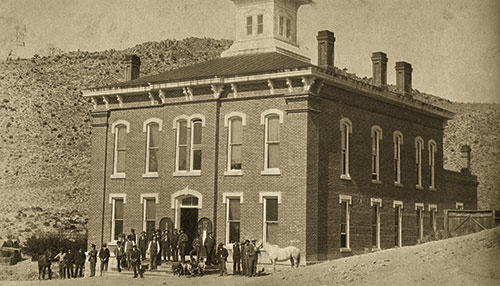 Sepia image of Belmont Courthouse circa 1880, with a group standing on front of it. ©Mrs. Della Dodson Collection