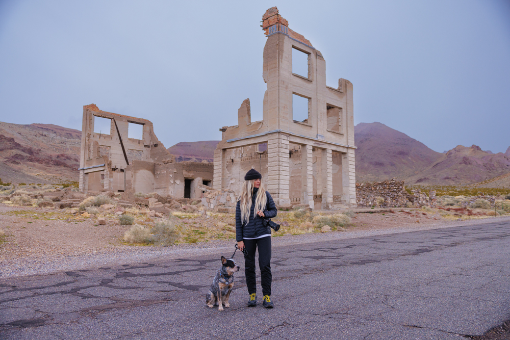 Woman standing with dog at Rhyolite ghost town.