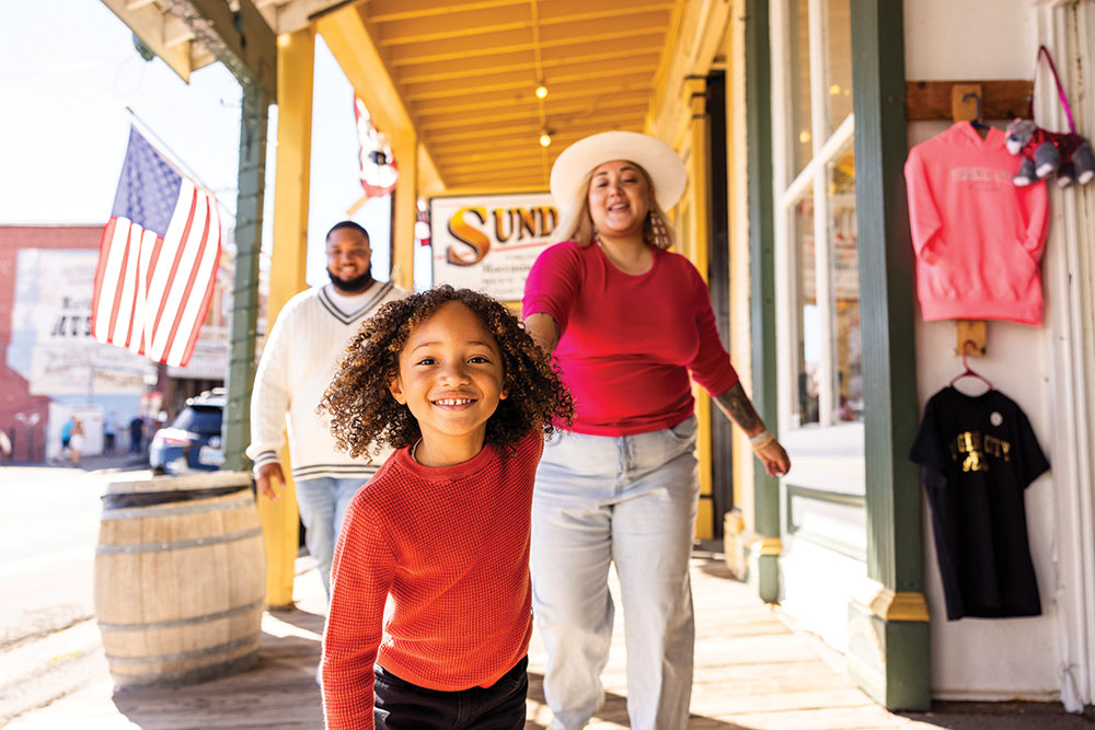 Little girl pulling her mom forward with dad walking beside them in Virginia City