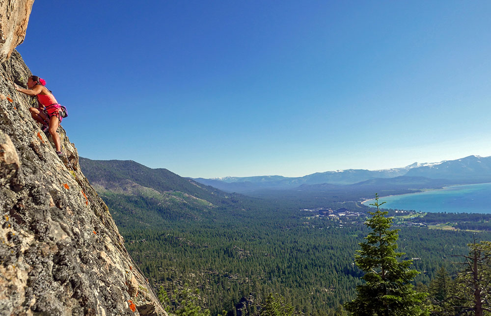 A rock climber in Lake Tahoe, with the lake in the distant background