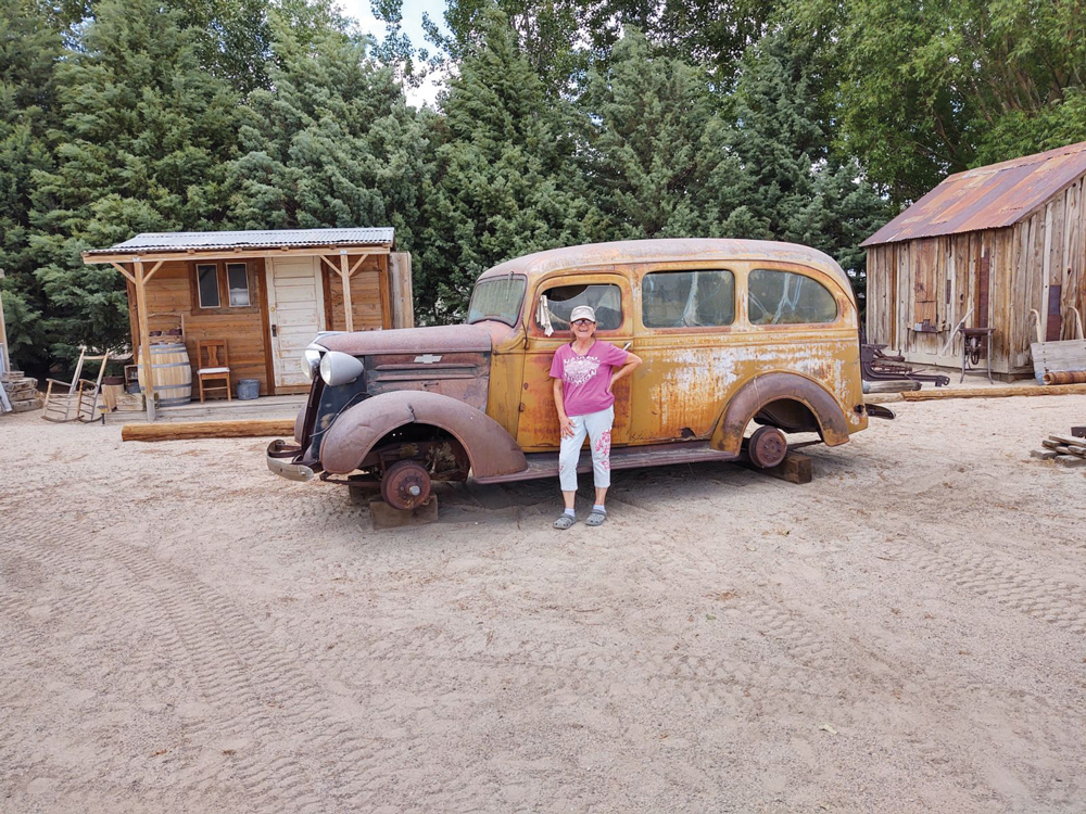 Linda Williams standing in front of an old school bus she rode on as a child at the Fish Lake Valley Heritage Center and Museum.